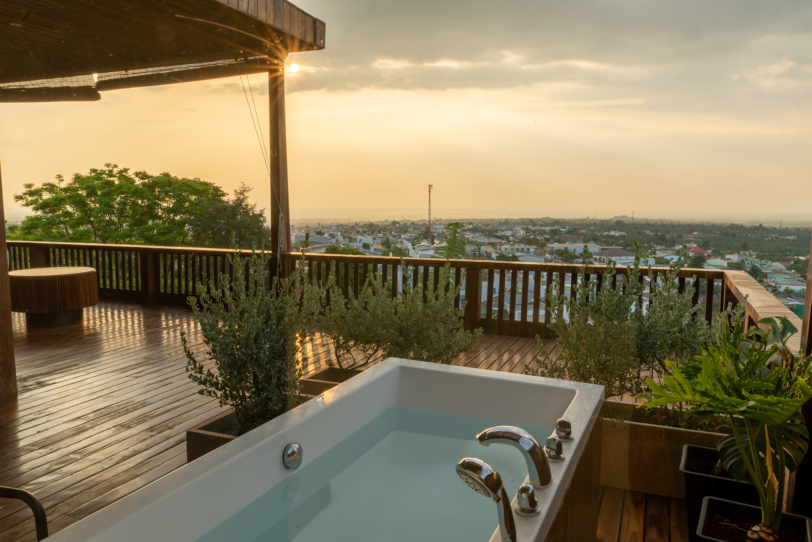 Phòng Deluxe Mountain View — kính kịch trần góc, bồn tắm ngoài trời trên ban công nhìn hoàng hôn